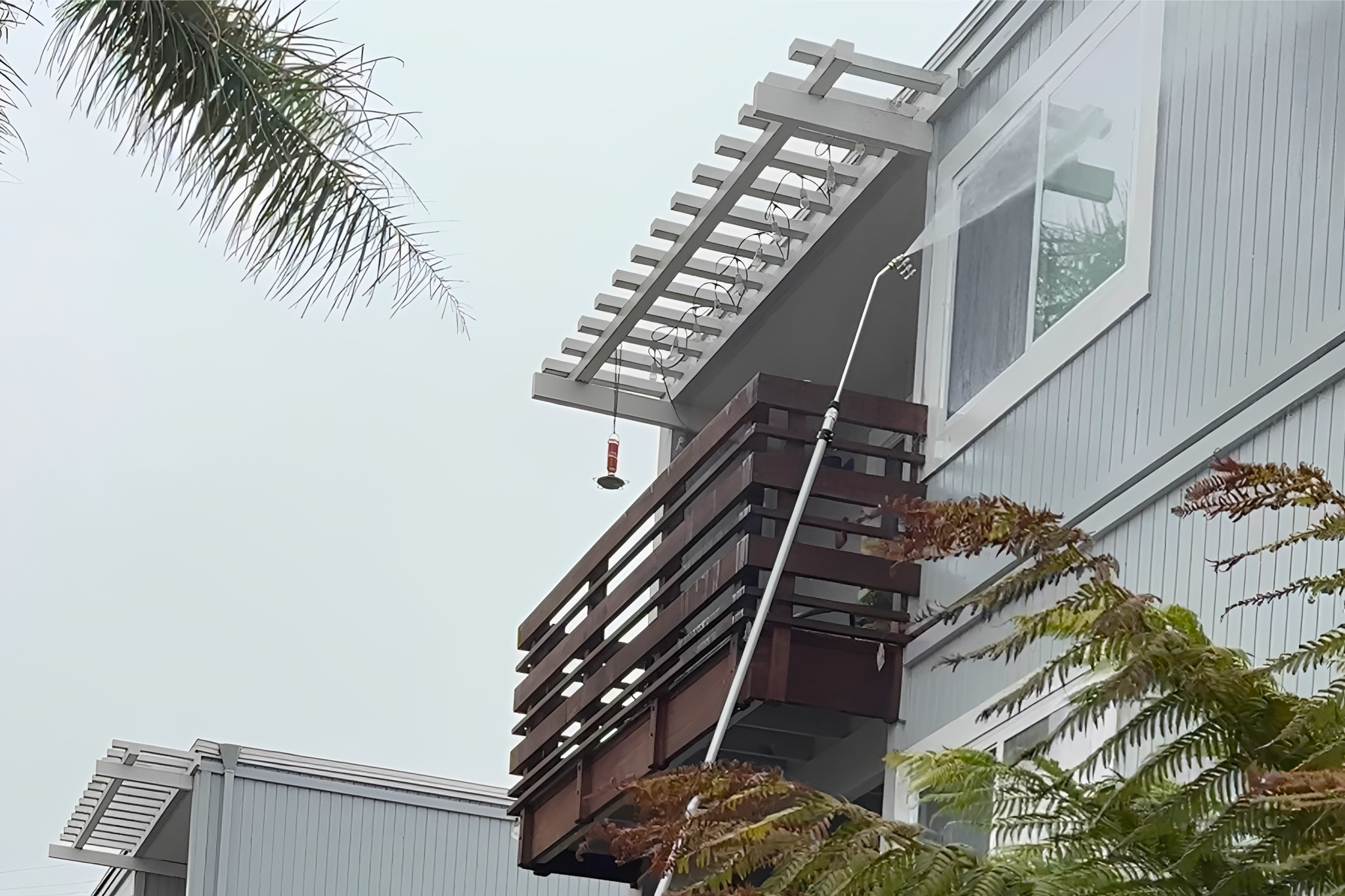 House balcony with wooden railing and plants.
