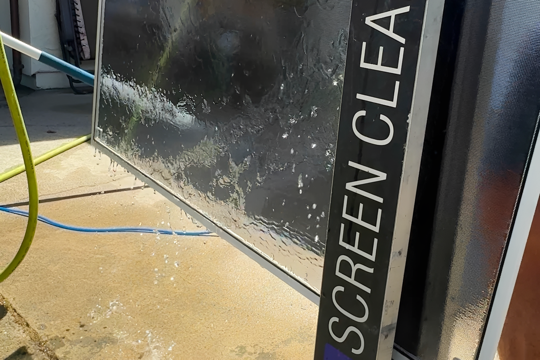 Cleaning screen with water and hoses.