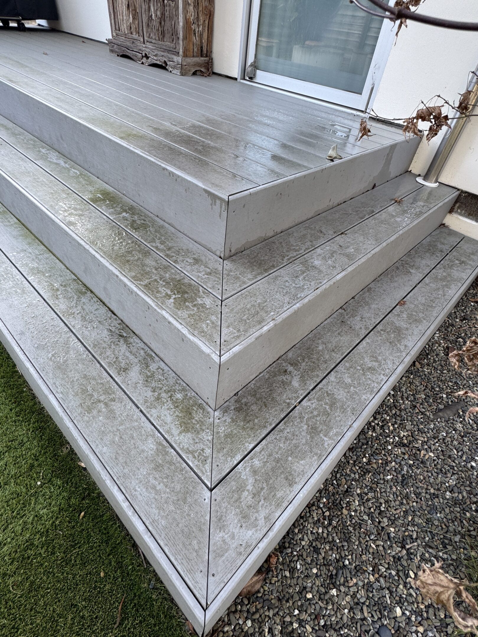 Wet wooden steps with green moss patches.