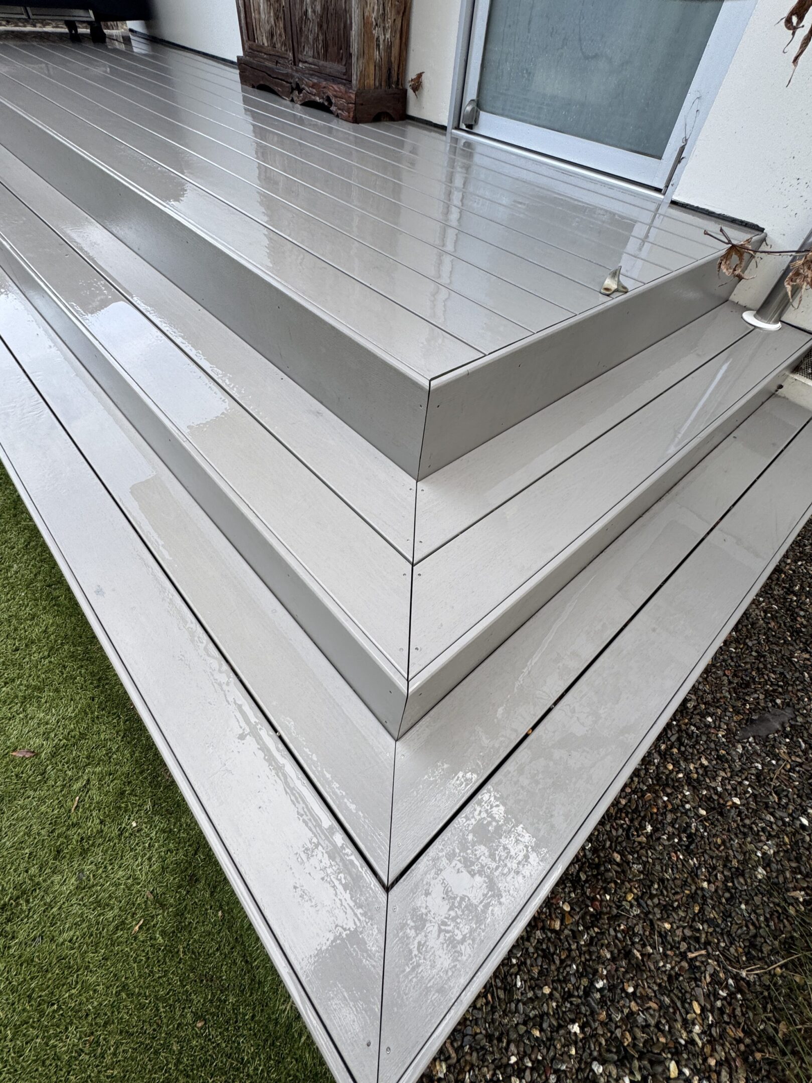 Wet wooden deck and steps, close-up view.
