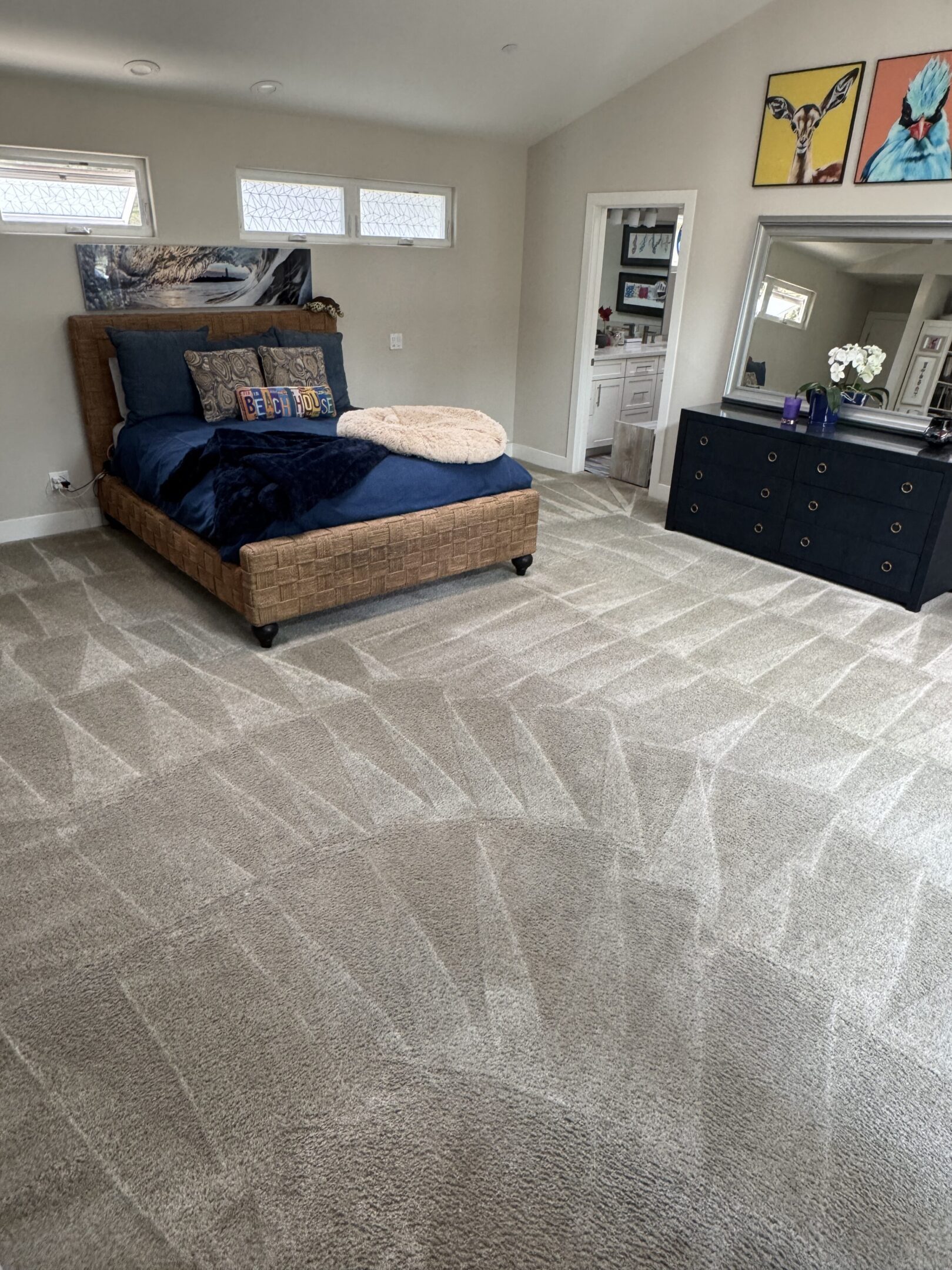 Spacious bedroom with bed and dresser.