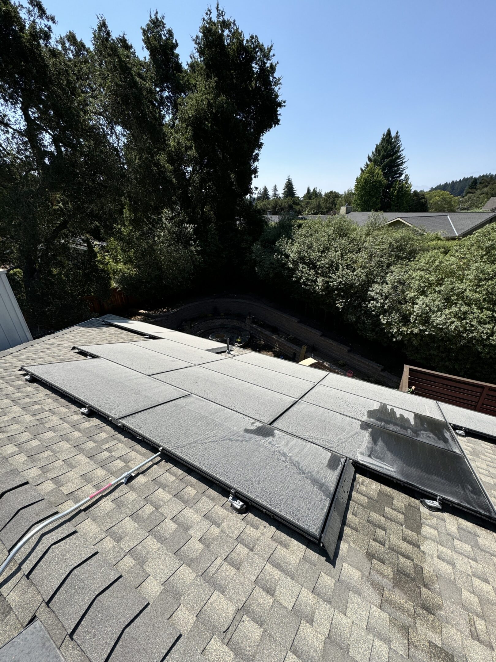 Rooftop solar panels with surrounding trees visible.
